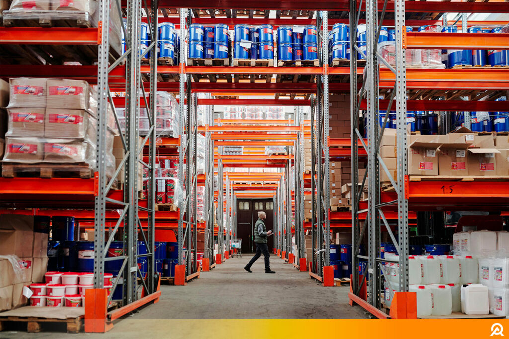 Contrôleur réalisant l’inspection de racks dans un entrepôt logistique, vérifiant la conformité structurelle selon les normes de sécurité.